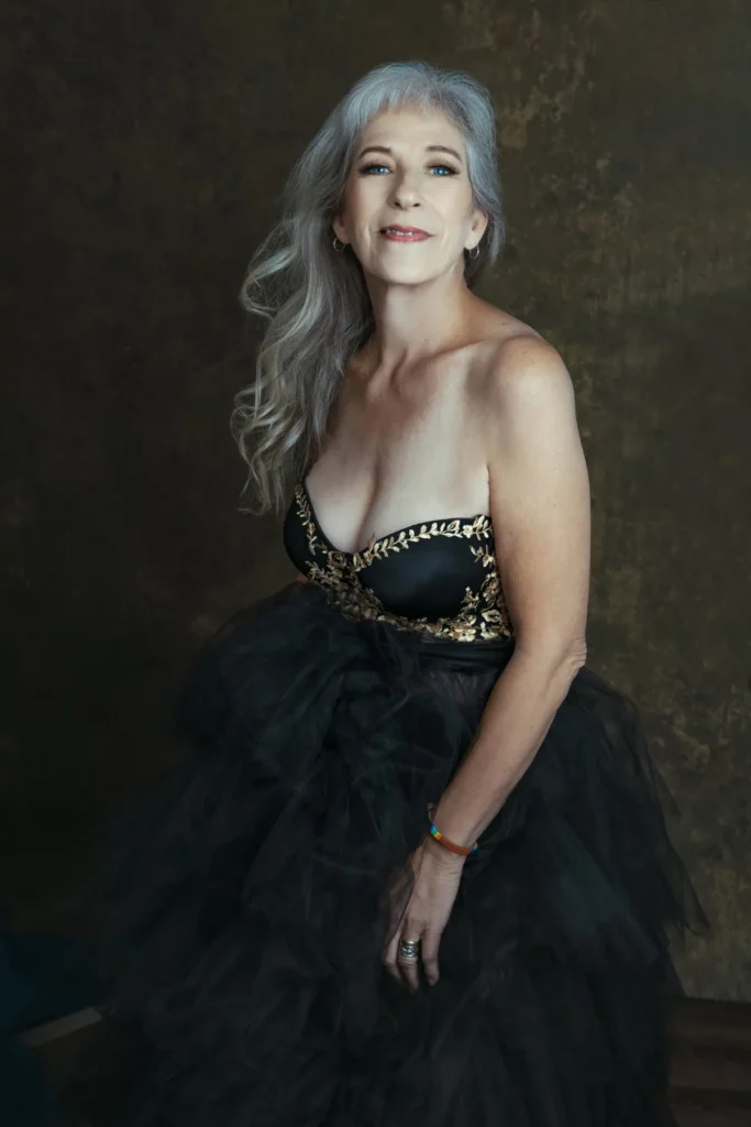 older woman wearing a elegant dress smiling and having a women's portrait experience Austin texas