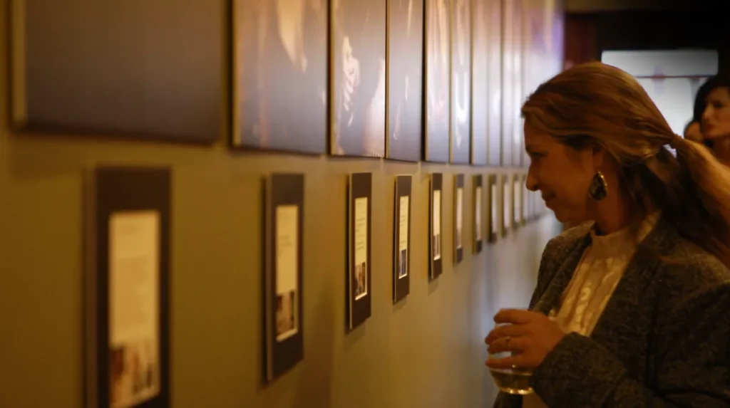 A woman looking at an art gallery on a wall showing women's portrait experience Austin
