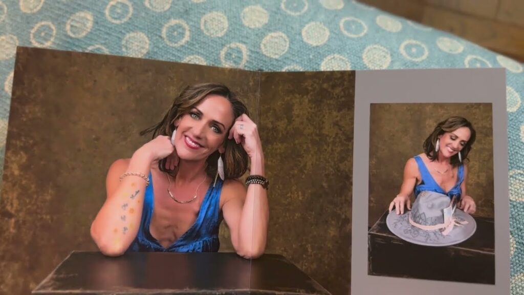 A photo of a woman in a blue dress poses with her arm on a table in one image and sits holding a gray hat in another; both images are displayed on a card. Tanya Eivin Photography