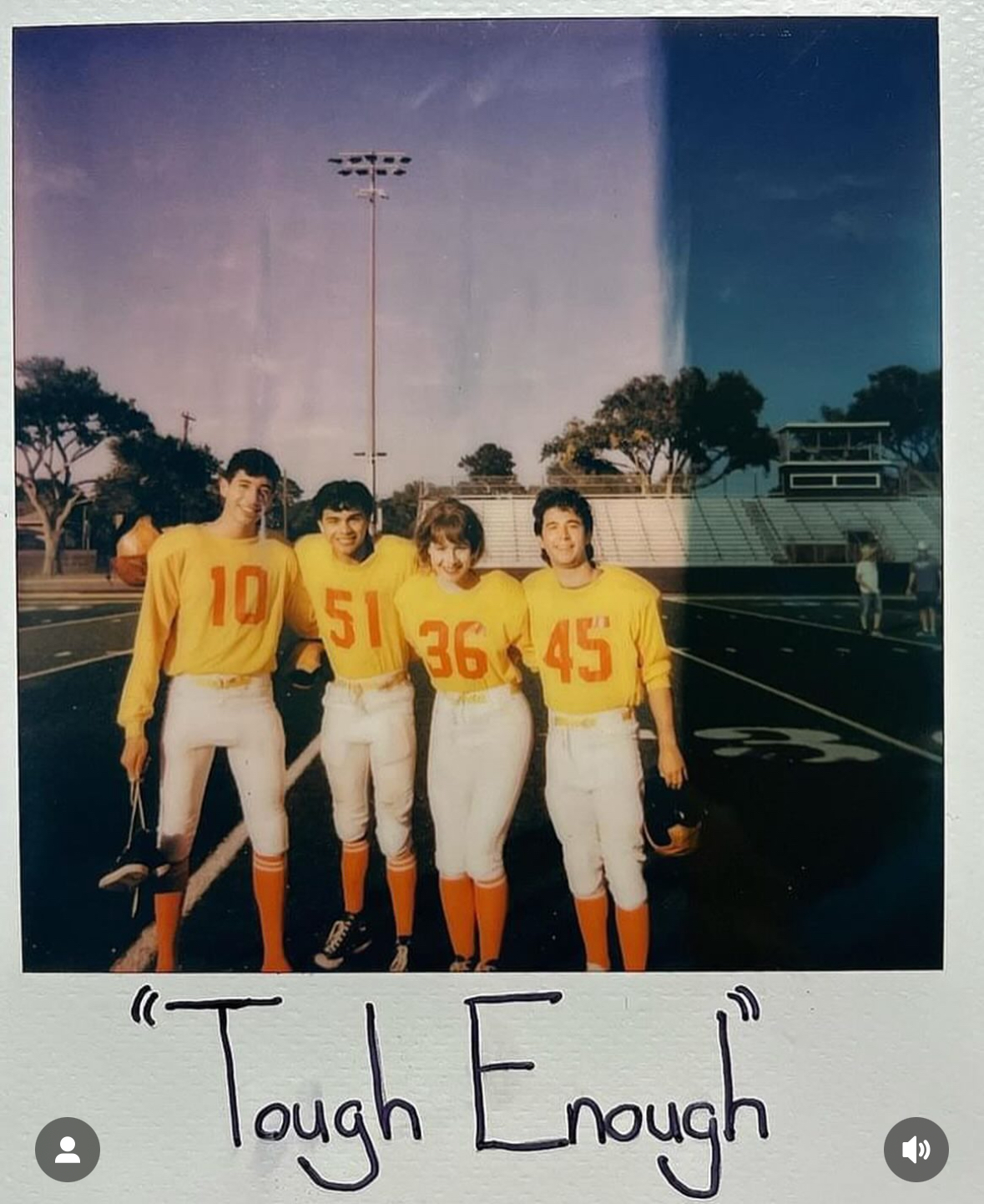 Four football players in yellow jerseys numbered 10, 51, 36, and 45 stand together on a field, posing and smiling for a group photo at sunset under stadium lights. Tanya Eivin Photography