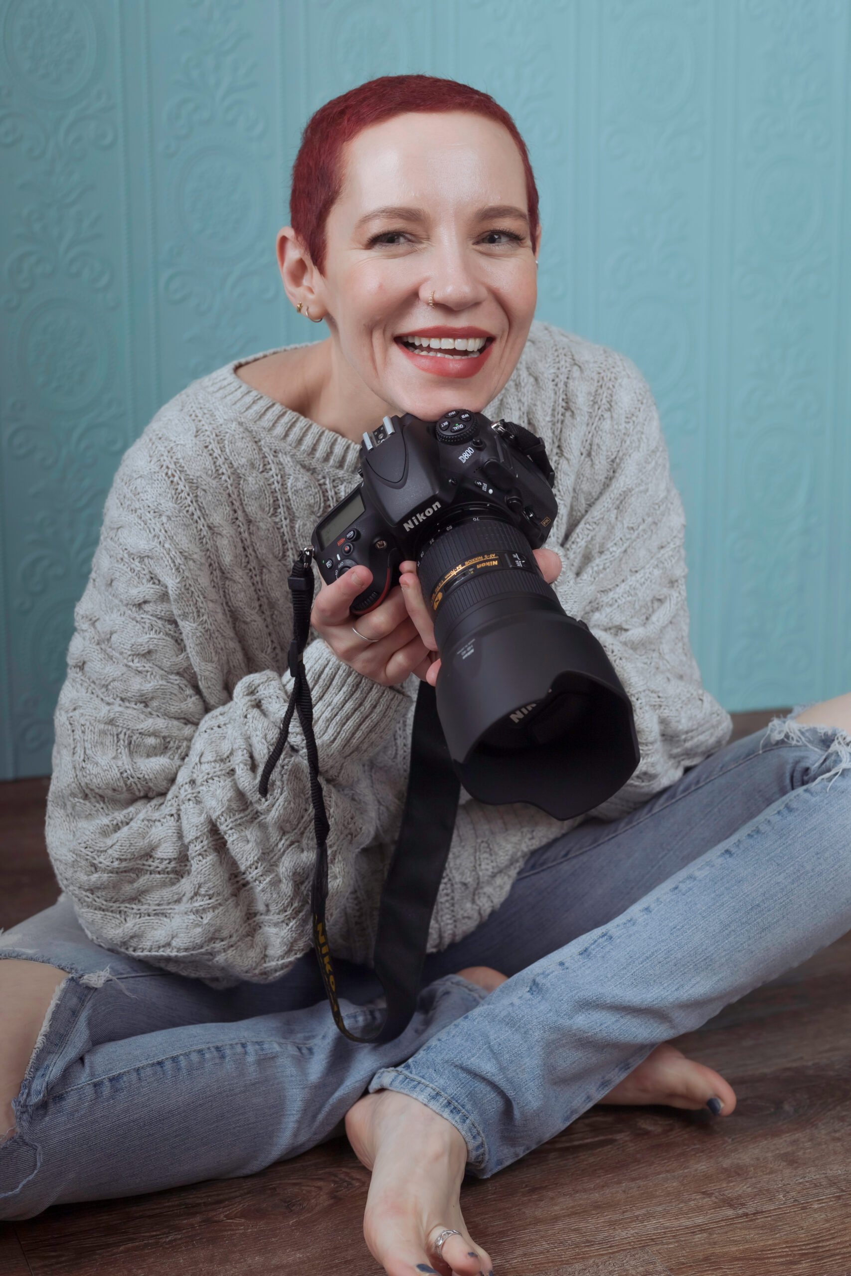 Tanya Eivin austin portrait photographer sitting on the ground holding her camera
