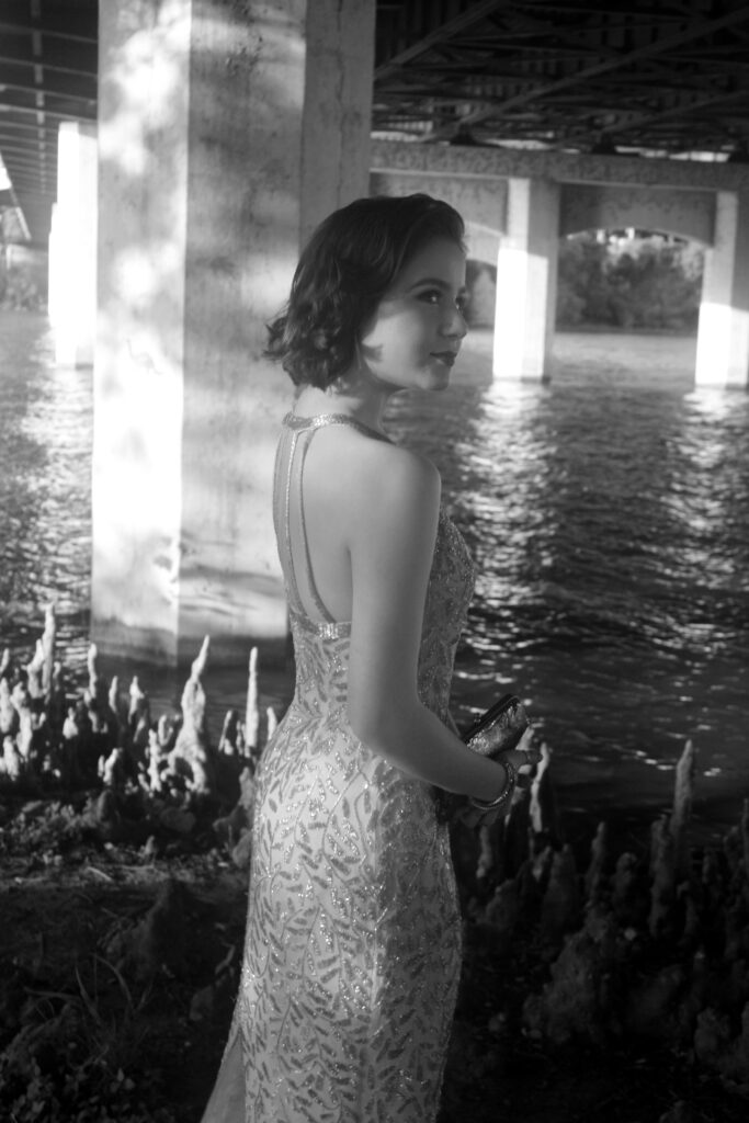 a black and white image of a senior in high school near water