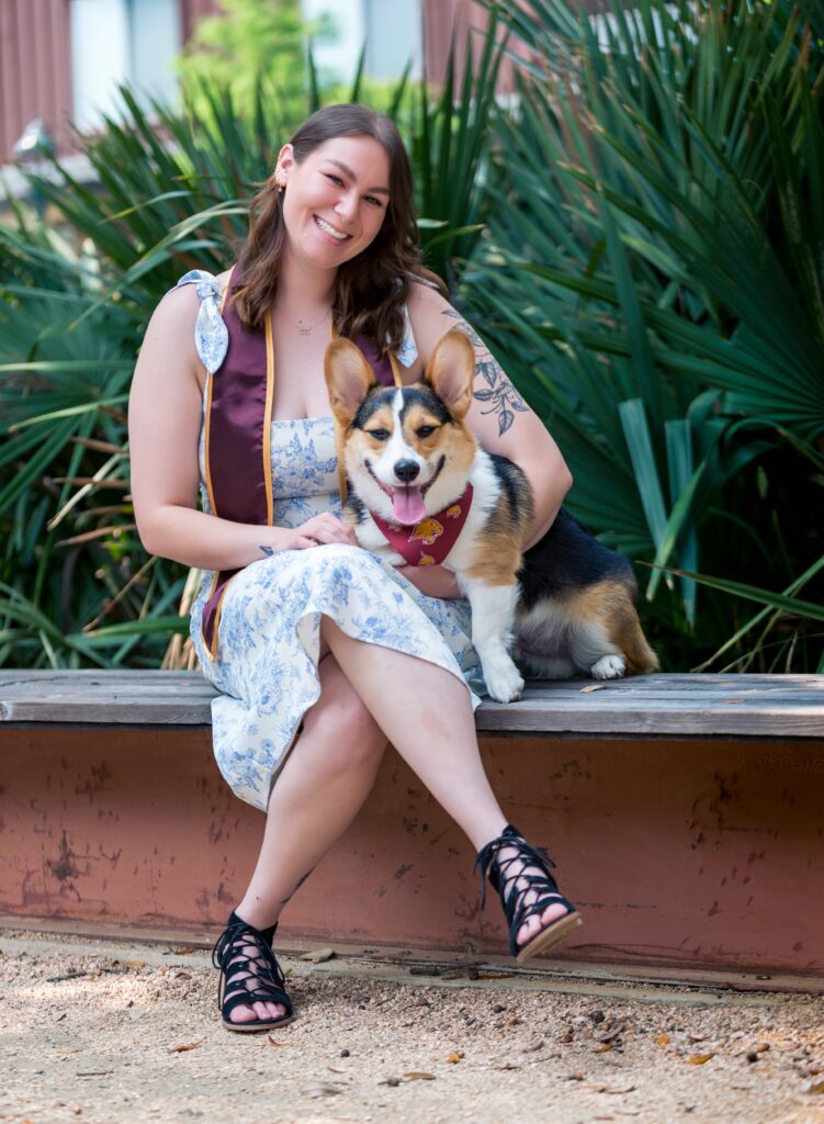a girl sitting with her dog for her senior photos