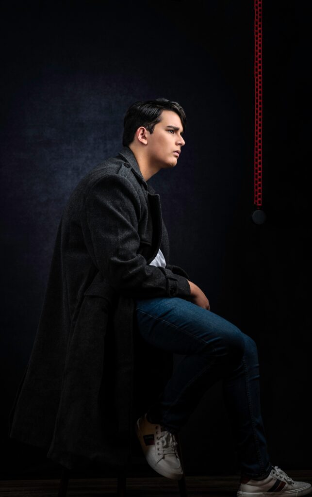 a senior boy in high school posing in a photography studio in austin texas for her senior portraits
